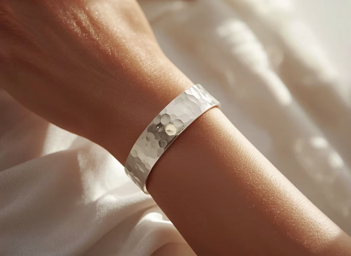 Hammered silver cuff bracelet on a wrist with soft studio lighting